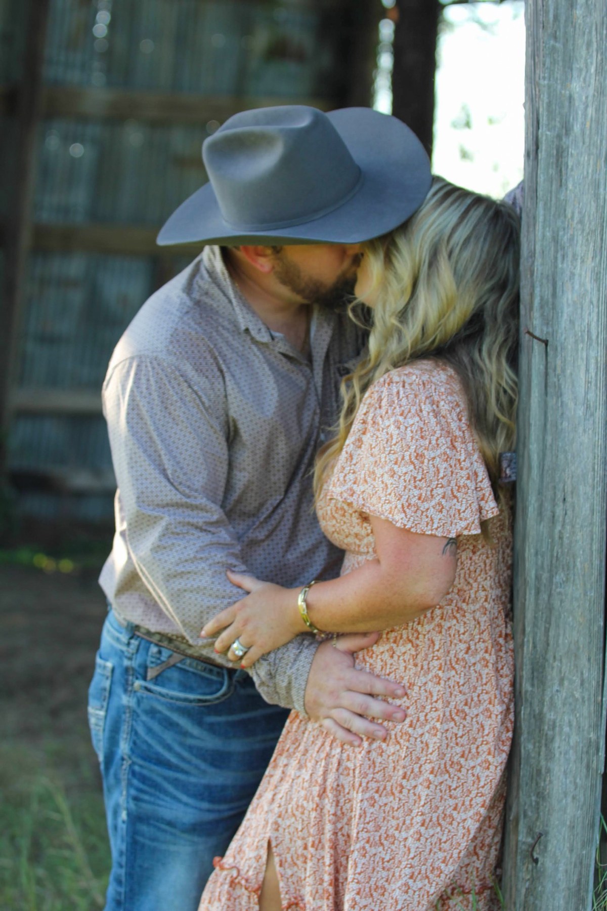 Couple together beside a rustic barn